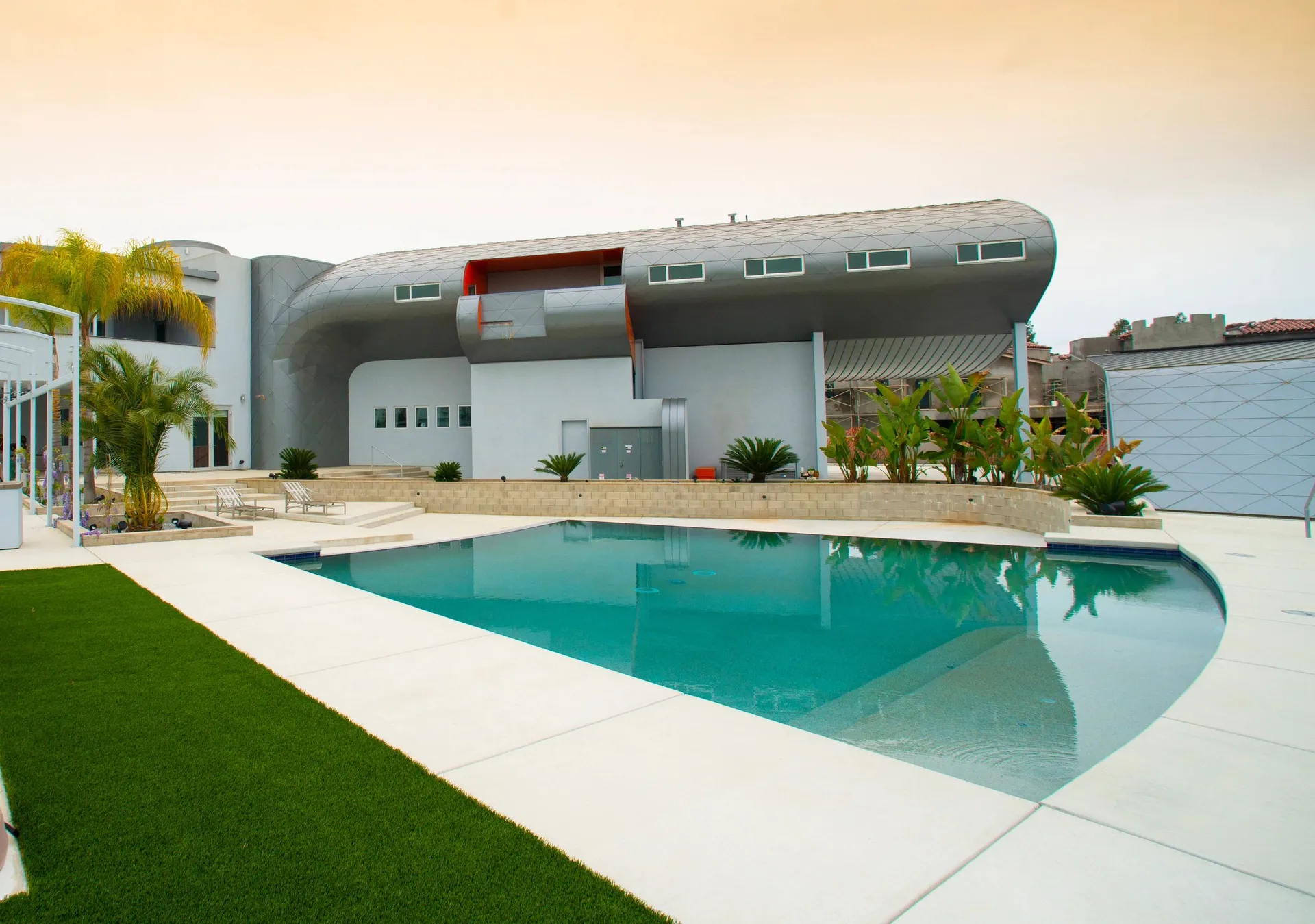 TUBE HOUSE. Rear elevation with the curved residence, pool, and outdoor terrace.